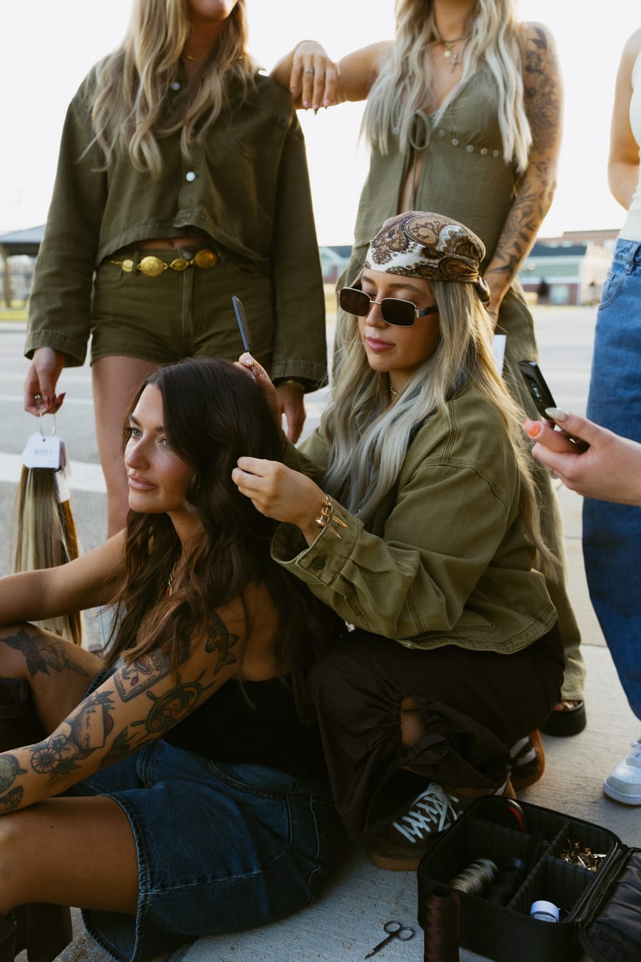 An Artistry Lounge stylist refining an editorial hairstyle outdoors